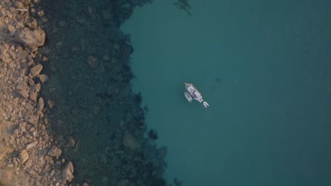 Drohne-Von-Oben-Nach-Unten-Erhebt-Sich-über-Dem-Boot-Im-Türkisgrünen-Sandwasser