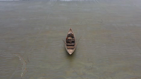 Zoomed-out-shot-of-a-lone-wooden-boat-on-the-tranquil-beach-in-Bangladesh