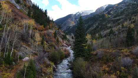 Cinematic-drone-aerial-4wd-truck-off-road-Marble-Crystal-Mill-stunning-autumn-Aspen-fall-colors-Southern-Colorado-Rocky-Mountains-peaks-Ouray-Telluride-camping-by-river-yellow-trees-follow-forward