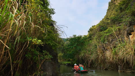 Rowing-boats-following-a-river-in-Ninh-Binh,-Vietnam