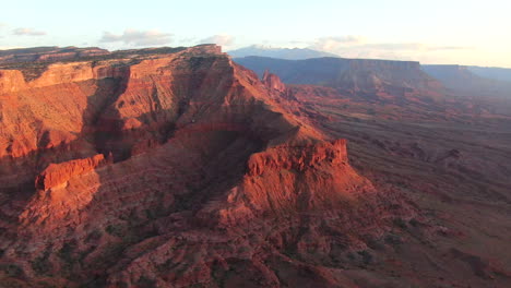 Aerial-cinematic-drone-Moab-Utah-dramatic-orange-sunset-mountain-snow-covered-peak-The-Big-Enchilada-landscape-Arches-National-Park-Castle-Valley-Castleton-Fishers-Tower-Green-River-camping-up-reveal