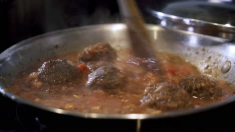 Boiling-sauce-of-vegan-meatballs-in-steel-pan-Preparing-ingredients-to-make-vegan-beyond-meatballs-with-spaghetti-and-meat-sauce