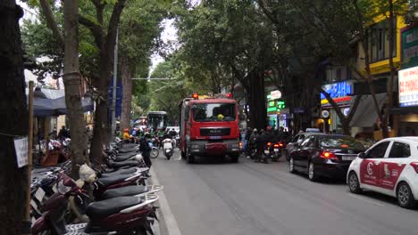 Fire-truck-drives-through-busy-streets-of-city,-warning-lights-flashing