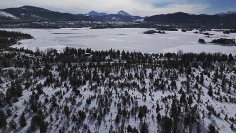 Downtown-Frisco-Colorado-aerial-cinematic-drone-Lake-Dillon-Marina-Keystone-Summit-cove-cloudy-snowy-winter-morning-view-Breckenridge-Silverthorne-Ten-Mile-Range-calm-unfrozen-ice-forward-reveal