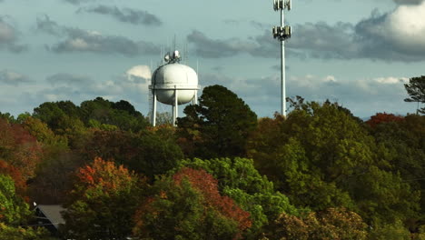 Water-Tank-And-Antenna-Tower-Behind-Forest-Trees-In-Autumn