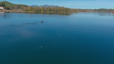 Person-In-Zwei-Ruderbooten-überquert-Den-Lake-Banyoles-Im-Herbst,-Girona