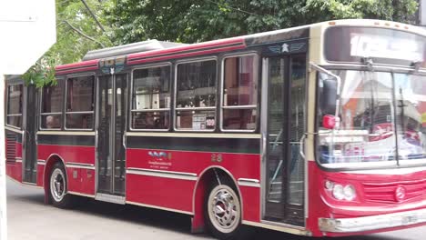 Roter-Bus-Fährt-In-Zeitlupe-An-Straßenkreuzung,-öffentliche-Verkehrsmittel