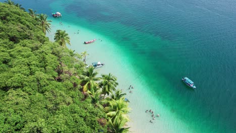 Drone-forward-shot-of-Estrella-beach-and-some-boats-located-in-the-Caribbean-Sea-in-Bocas-del-Toro,-Panama