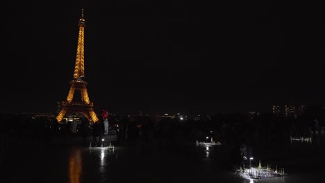 Tourist-Macht-Fotos-Von-Sich-Selbst,-Während-Er-Nachts-Am-Place-Du-Trocadero-Rote-Luftballons-Vor-Dem-Eiffelturm-Hält