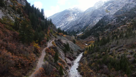 Cinematic-drone-aerial-4wd-off-road-Marble-Crystal-Mill-stunning-autumn-Aspen-fall-colors-Southern-Colorado-Rocky-Mountains-peaks-Ouray-Telluride-camping-by-river-yellow-trees-backward-motion