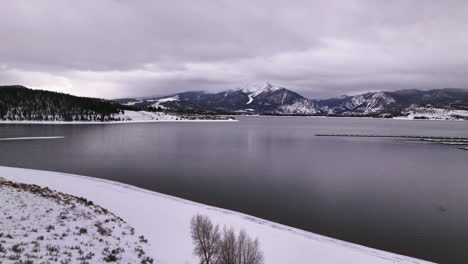 Lake-Dillon-Keystone-Summit-cove-Colorado-aerial-cinematic-drone-cloudy-snowy-winter-morning-view-Frisco-Breckenridge-Silverthorne-Ten-Mile-Range-peaceful-calm-frozen-ice-forward-motion-reveal