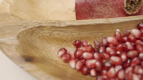 Granatapfelkerne-In-Einem-Holzteller-Schwenken,-Entsaften-Und-Frische-Zutaten-Und-Frische-Ganze-Granatäpfel-Verwenden