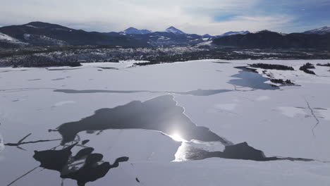 Downtown-Frisco-toward-Keystone-Colorado-aerial-cinematic-drone-Lake-Dillon-Marina-Summit-cove-cloudy-snowy-winter-morning-view-Silverthorne-Ten-Mile-Range-Breckenridge-calm-unfrozen-ice-circle-right
