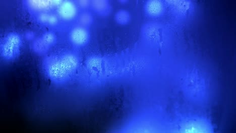 Animation-of-glowing-blue-bokeh-background-seen-through-a-wet-and-dirty-glass