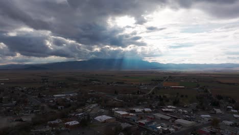 Establishing-drone-shot-going-towards-storm-clouds-with-sunlight-coming-through