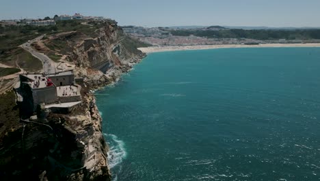 Drone-shot-of-Nazaré-lighthouse-heading-to-the-beach