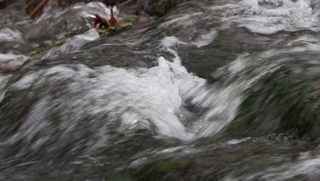 Sich-Schnell-Bewegendes-Wasser,-Das-In-Einem-Kleinen-Bach-über-Felsen-Fließt