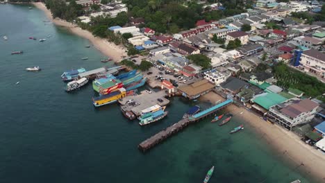 Aerial-drone-shot-of-Koh-Tao-Thailand-boat-pier-in-southeast-Asia,-small-fishing-and-diving-village-on-the-blue-water