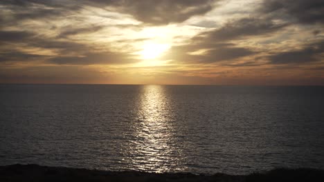 Goldener-Sonnenuntergang-über-Dem-Meer-Mit-Bewölktem-Himmel