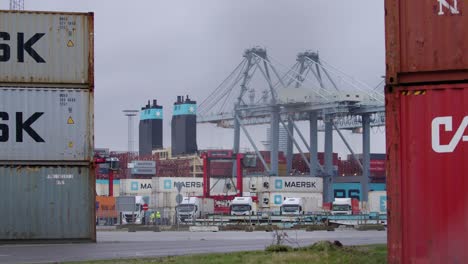 Maersk-ship-being-loaded-with-shipping-container-while-cranes-are-driving-around