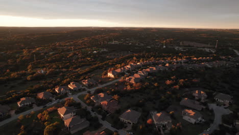 aerial-shot-over-an-American-suburb-and-houses-at-sunset,-dolly-forward