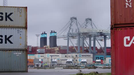 Maersk-Schiff-Wird-Mit-Schiffscontainern-Beladen,-Während-Ein-Kran-Und-Ein-LKW-Herumfahren