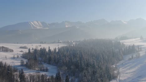 Remote-village-in-Tatra-Mountain,-pristine-forest-in-snow-covered-valley,-winter-landscape