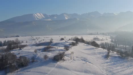 Paisaje-Aéreo-Invernal-De-Las-Montañas-Tatra-En-Zakopane,-Paisaje-Nevado-En-Niebla-Iluminada-Por-El-Sol