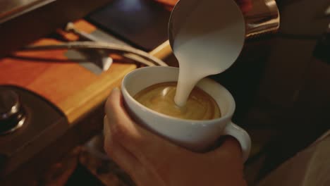 Barista-Bereitet-Cappuccino-Mit-See-Zu