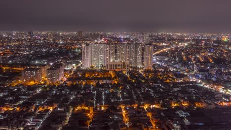 Night-aerial-hyperlapse-in-dense-urban-area-with-large-residential-development-and-traffic-on-main-roads