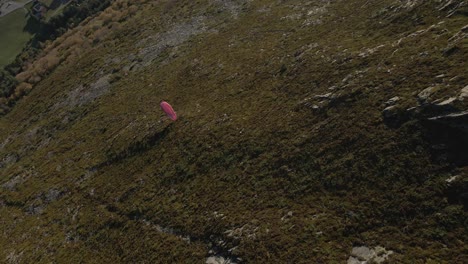 Luftaufnahme-Von-Oben-Nach-Unten-Eines-Gleitschirms,-Der-An-Einem-Sonnigen-Tag-In-Norwegen-über-Grüne-Berge-Fliegt
