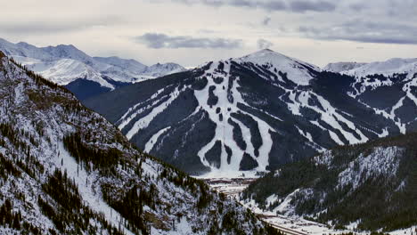 Ski-runs-trails-Distant-i70-Copper-Mountain-Leadville-Colorado-Winter-December-Christmas-aerial-drone-cinematic-landscape-Silverthorne-Vail-Aspen-Ten-Mile-Range-cloudy-Rocky-Mountains-left-circle
