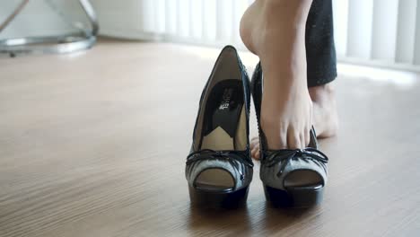 Mujer-Descalza-Probándose-Zapatos-De-Tacón-Grises-Y-Negros