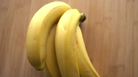 Racimo-De-Plátano-Girando-Sobre-Fondo-De-Madera
