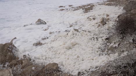 Seafoam-blowing-in-strong-winds-on-the-rocky-beaches-of-Greece