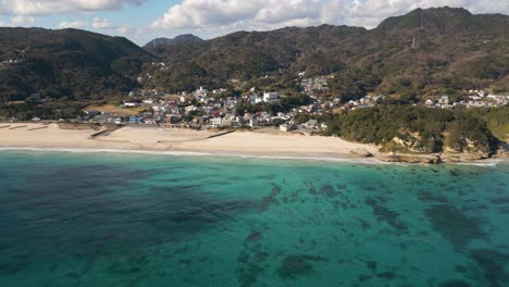 Slow-motion-aerial-sideways-drone-flight-over-beautiful-sand-beach-in-Izu,-Japan