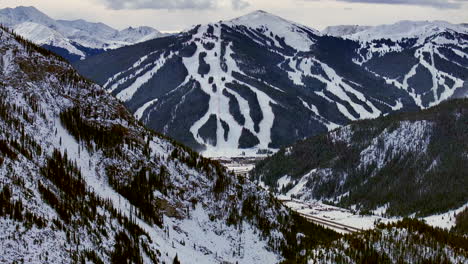 Ski-runs-trails-Distant-i70-Copper-Mountain-Leadville-Colorado-Winter-December-Christmas-aerial-drone-cinematic-landscape-Silverthorne-Vail-Aspen-Ten-Mile-Range-cloudy-Rocky-Mountains-forward-reveal