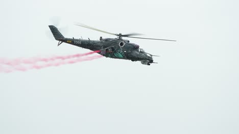 Military-Mil-Mi-24-attack-helicopter-fly-and-leave-red-smoke-trail-behind