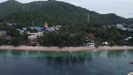 Aerial-drone-shot-of-Koh-Tao-Thailand-in-southeast-Asia,-vacation-resorts,-and-a-small-fishing-and-diving-village-on-the-blue-water-and-jungle