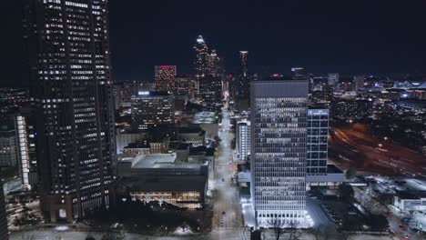 Aerial-forward-flight-over-illuminated-city-of-Atlanta-At-night-and-traffic-on-main-road-in-downtown