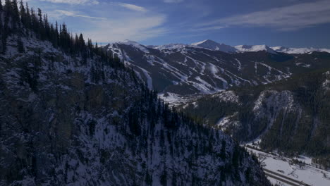 Ski-runs-Copper-Mountain-Colorado-Winter-December-Christmas-aerial-drone-cinematic-landscape-i70-Leadville-Silverthorne-Vail-Aspen-Ten-Mile-Range-blue-sky-clouds-past-Rocky-Mountains-circle-right