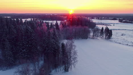 Sonnenuntergang-über-Einer-Verschneiten-Winterlandschaft---Luftüberflug