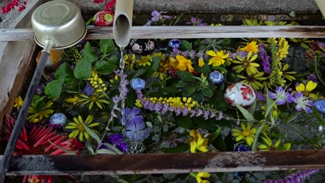 Filmische-Ansicht-Einer-Typischen-Japanischen-Chozu-Wasserkelle-Am-Tempel-Mit-Bunten-Blumen