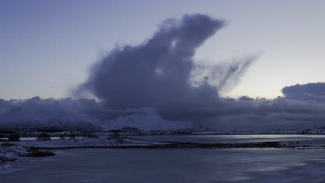 Panoramic-view-of-giant-clouds-over-snow-covered-mountains-in-a-cold-winter-day
