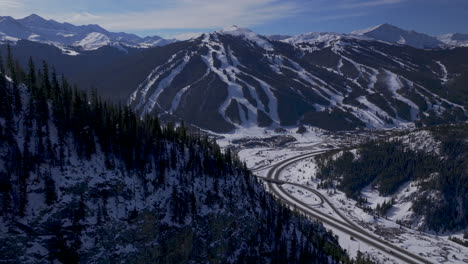 Copper-Mountain-Colorado-Winter-December-Christmas-aerial-drone-cinematic-landscape-i70-Leadville-Silverthorne-Vail-Aspen-Ten-Mile-Range-blue-sky-clouds-past-Rocky-Mountains-parallax-zoom-forward