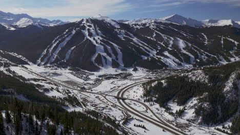 Copper-Mountain-Colorado-Winter-December-Christmas-aerial-drone-cinematic-landscape-i70-Leadville-Silverthorne-Vail-Aspen-Ten-Mile-Range-blue-sky-clouds-past-Rocky-Mountains-parallax-forward-zoom
