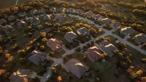 aerial-shot-over-American-suburban-homes-at-sunset,-dolly-forward