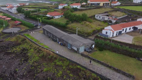 Reveal-shot-of-holiday-home-near-coast-at-Fajã-Grande-town-in-Flores-Azores,-aerial