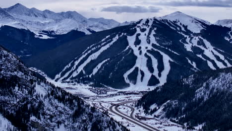 Ski-runs-trails-Distant-i70-Copper-Mountain-Leadville-Colorado-Winter-December-Christmas-aerial-drone-cinematic-landscape-Silverthorne-Vail-Aspen-Ten-Mile-Range-cloudy-Rocky-Mountains-slow-reveal