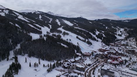 Parking-lot-base-half-pipe-big-air-Jump-ski-snowboard-gondola-ski-lift-aerial-drone-cinematic-Copper-Mountain-base-Colorado-Winter-December-Christmas-Ski-runs-trails-landscape-forward-reveal